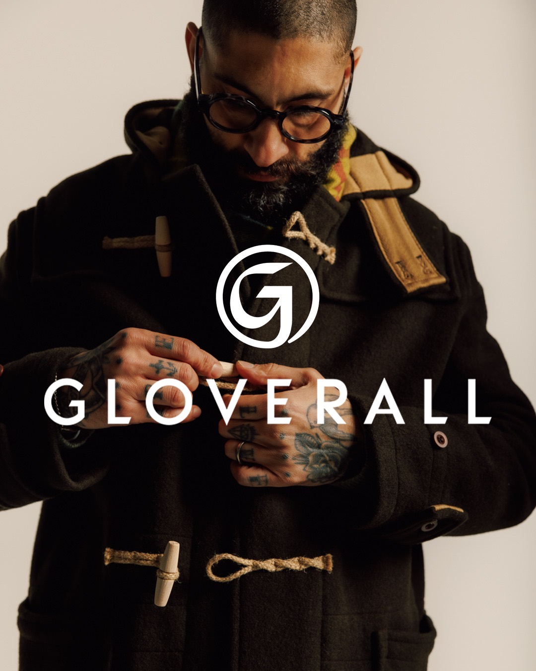Man fastening the wooden toggles of a black Gloverall duffle coat