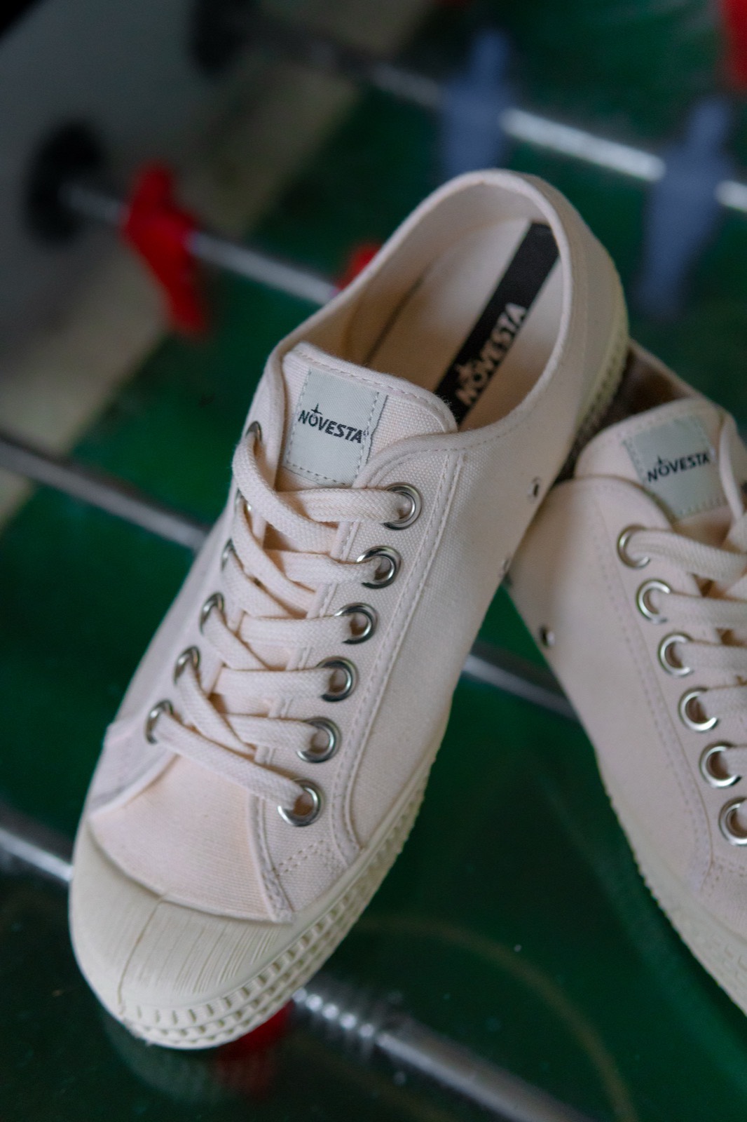 Off-white Novesta canvas sneakers resting on a table football table