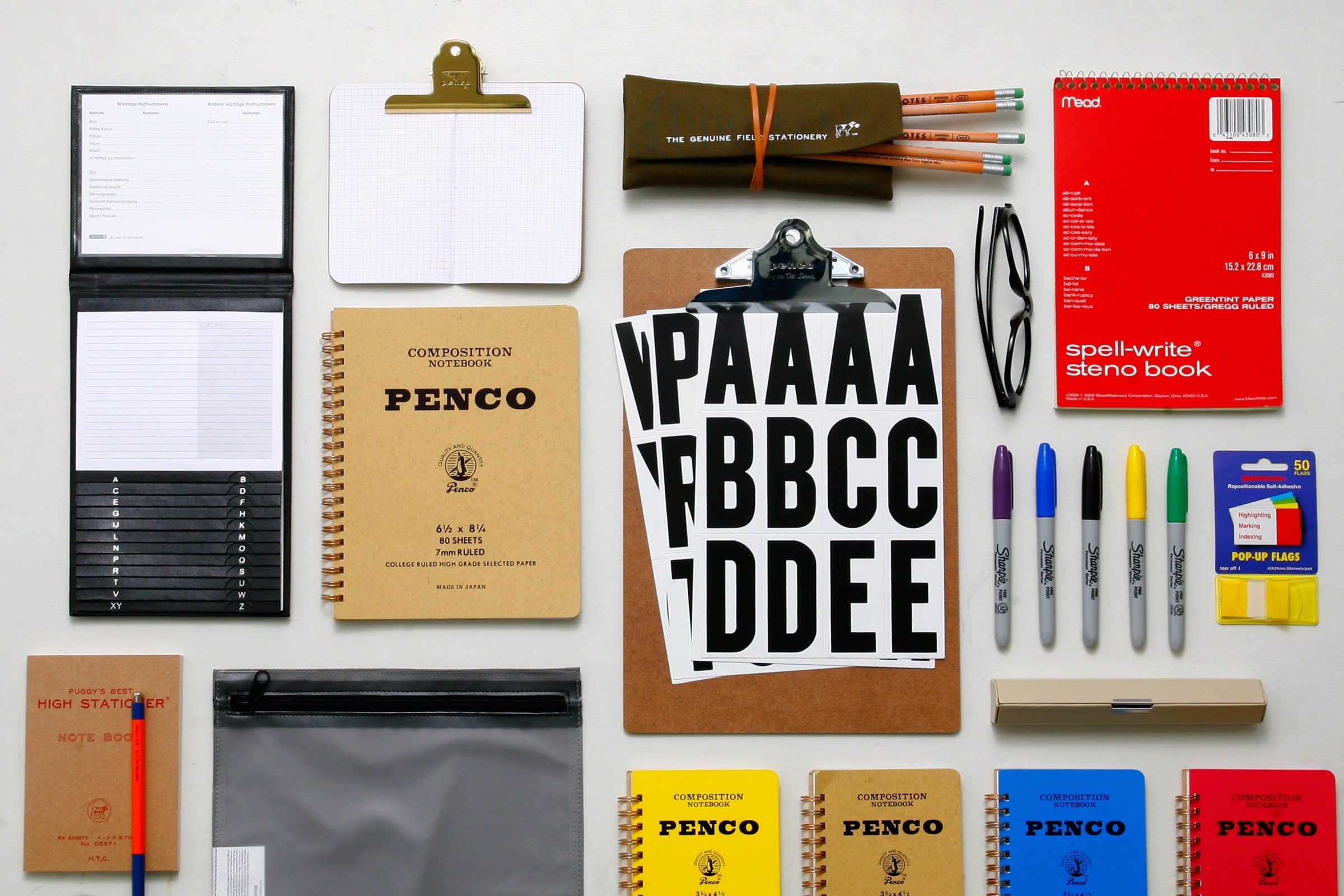 Penco stationery laid out flat: notebooks, pens, markers, a clipboard and letter stickers